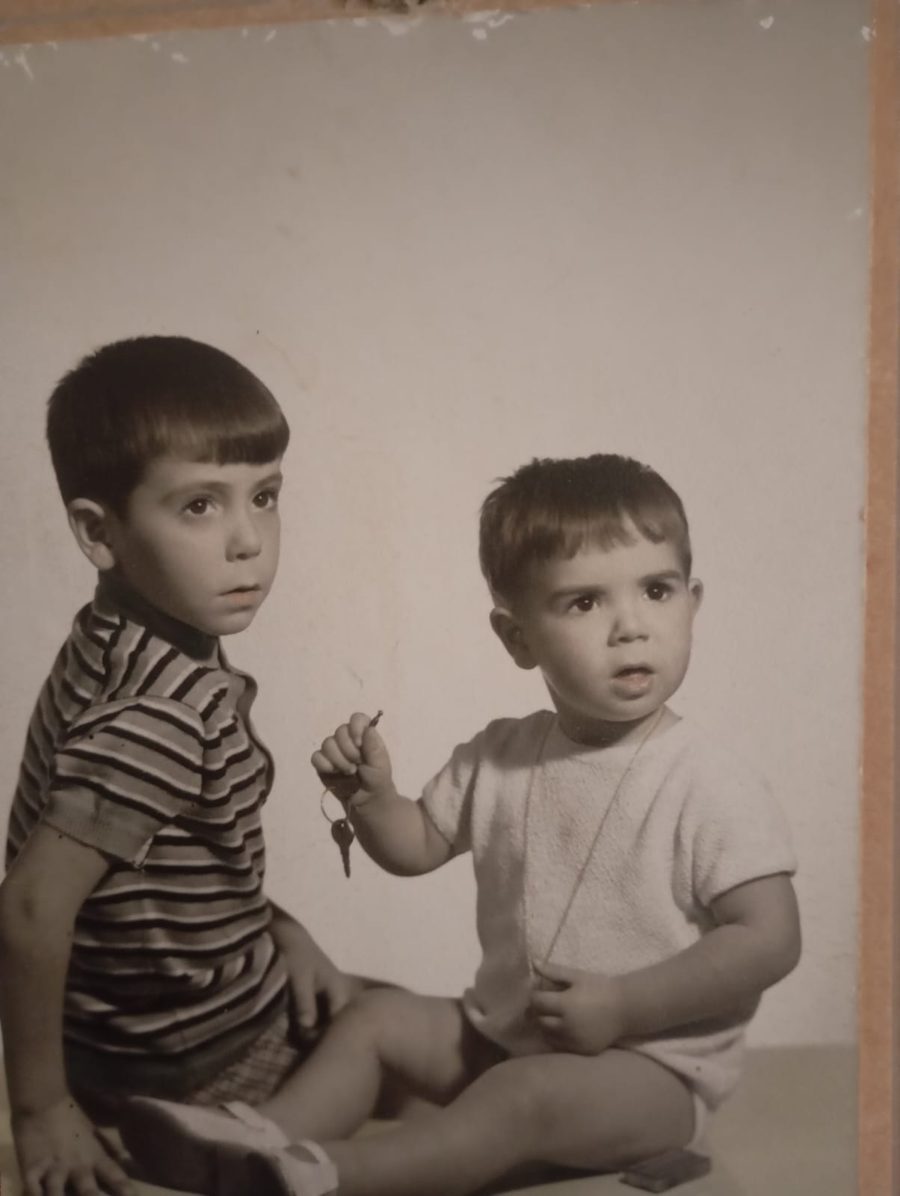 Fotografia antiga en blanc i negre de dos nins asseguts; el petit sosté una clau.